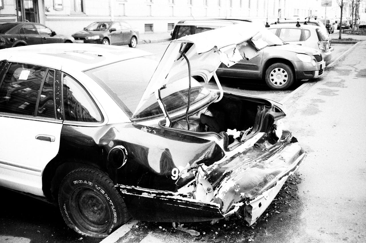 Crafting Captivating Headlines: Your awesome post title goes here A black and white photo of a wrecked car on an urban street, highlighting vehicle damage.
